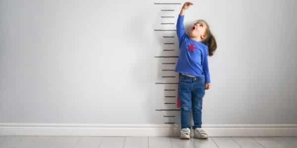 girl next to a height chart representing social media growth